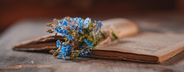 Vintage books with a bouquet of spring wild flowers. Nostalgic vintage atmospheric background.