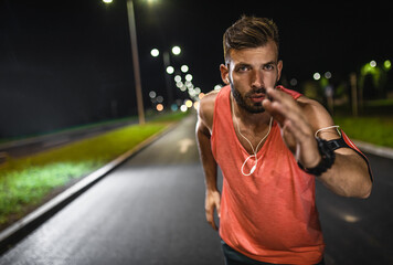 Man running through the city street at night.