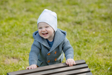 Cute, sweet boy with a charming smile close-up. Portrait of a 1 year old baby in a funny hat with...