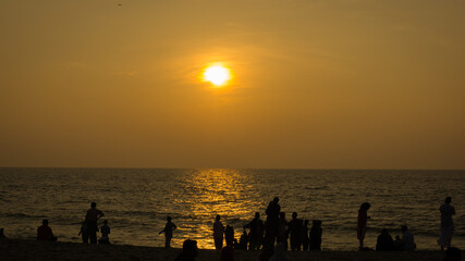 Naklejka na ściany i meble Beautiful sunset beach, with silhouette people