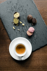 colored cut candy truffle on a black plate with espresso coffee
