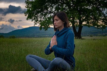 A young woman doing yoga in the field.