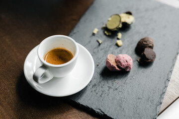 colored cut candy truffle on a black plate with espresso coffee
