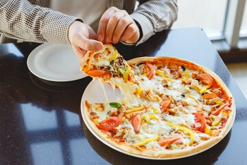 Delicious pizza food delivery. Caucasian man take piece of delicious Italian pizza with mozzarella cheese in cafe, restaurant or at home. Fast food pizza delivery.