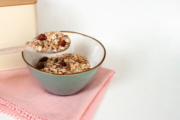Muesli breakfast, oatmeals in ceramic bowl with wood spoon. Healthy food. Copy space text.