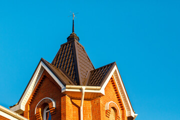 A small tower on the roof. New metal roof of a brick cottage with a system of drains against the...
