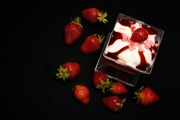 Strawberry dessert with strawberries on a black background, top view.