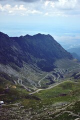 asphalt road crossing rocky mountains in spring season