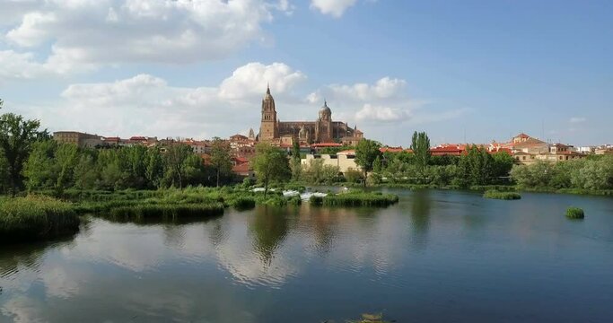 Aerial footage. The new cathedral of Salamanca reflected in the Tormes river. Spain.