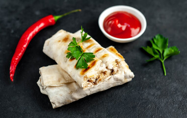 
Burritos wraps with chicken, mushrooms, and vegetables on a stone background. Delicious shawarma