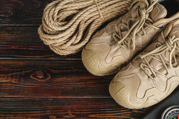 Hiking boots and rope hank on wooden board