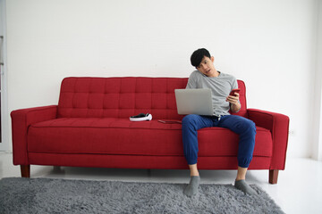 Man sitting on sofa stay at home using mobile cellphone or smartphone
