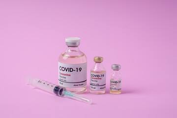 Coronavirus vaccination glass bottle on a pink background Covid-19 Vaccination Equipment Research on the concept of pandemic influenza vaccines around the world.