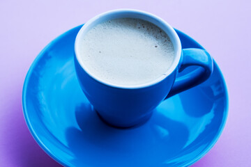 blue cup with coffee on pink background