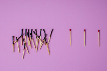 
Matchsticks on a pink background, laid out with a distance.