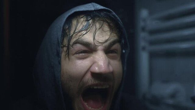 Sweaty and tired Young street fighter or boxer yelling in front of mirror. He's motivating himself. Color Graded Version