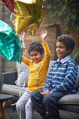 Children boy and girl sitting together outdoor and play with balloon.