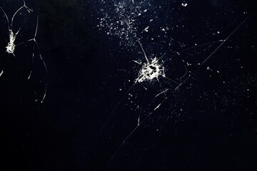 Cracks on the glass. Detail of broken glass.Photo of dark glass from mobile phone  with cracks.