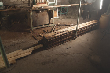 Focus on wooden planks. Carpenter cutting a wooden plank with a carpentry machine.