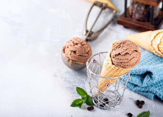 Delicious coffee or chocolate ice cream in waffle cone for dessert. Summer healthy food concept, lactose free. Copy space.