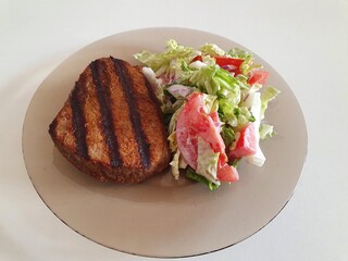 grilled meat with vegetables on the white table