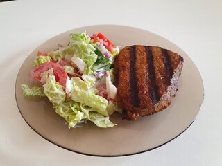 grilled meat with vegetables on the white table