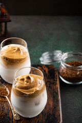 Dalgona coffee in glass cup. Korean trendy drink from instant coffee, milk and ice. Summer beverage concept with copy space.
