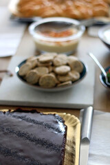 Various food served on a table: Chocolate poppy seed cake, strawberries, whipped cream and crackers. Selective focus.