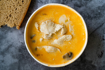 Take Away Thai Style Tom Kha Gai Soup with Coconut Milk, Chicken and Galangal in Plastic Bowl Package / Container.