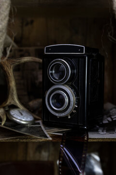 Vintage film camera and old photographs in the old, wooden crate