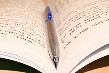 close up of an open book with pen