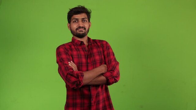 Portrait of young smiling man on green screen. Happy Indian businessman gesturing thumb up on Alpha Channel background. People and gestures concept.
