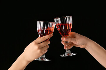 Female hands with glasses of champagne on dark background