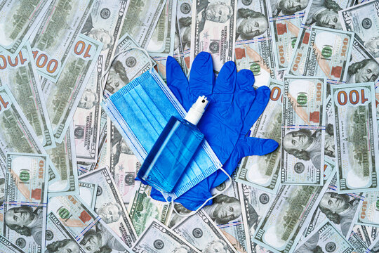 Protective medical mask, gloves and sanitizer on a background ofUS Dollar banknotes