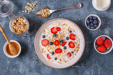 Healthy breakfast, bowl with oat granola, milk and berries.