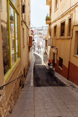 Fototapeta na wymiar Scooter near buildings on walkway of urban street in Catalonia, Spain