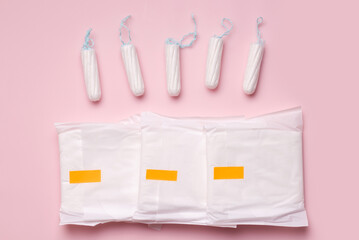 Menstruation. Tampons and pads on a pink background