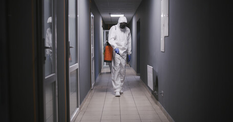 Men in hazmat suits disinfecting building