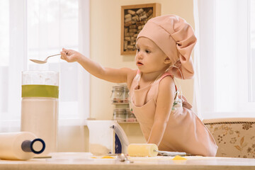 Little girl cooks at home in the kitchen