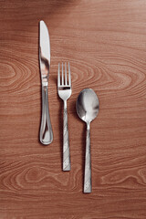 metal cutlery lie on a wooden table