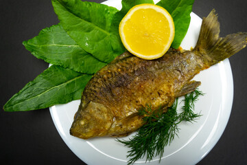 Fried crucians in a pan. Cooking fried fish. A dish of fried crucian carp. Tasty river fish.