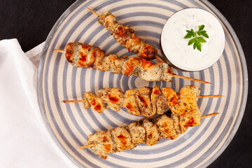 Bbq meat on wooden skewers on plate. Top view, flat lay.