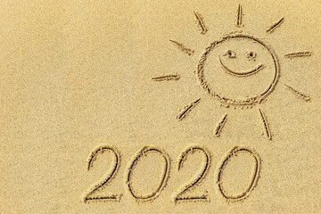 Fototapeta na wymiar Drawing sun and 2020 on the sand
