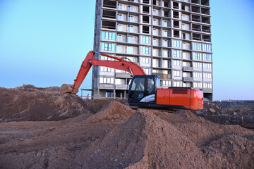 Excavator working at construction site on earthworks. Backhoe digging building foundation. Paving...