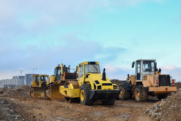Soil Compactor, bulldozer and wheel loader during the construction of road at construction site. Heavy machinery for leveling the ground, land clearing, grading, pool excavation, trenching