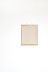 Blank paper canvas sheet poster on white wall. Mockup with copy space. Art / picture / concept