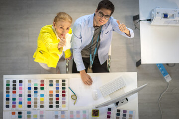 Senior designers and young male designers Raise your thumb and look at the camera. Top view