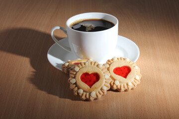 Cup of coffee and sweet cookies on a wooden kitchen table