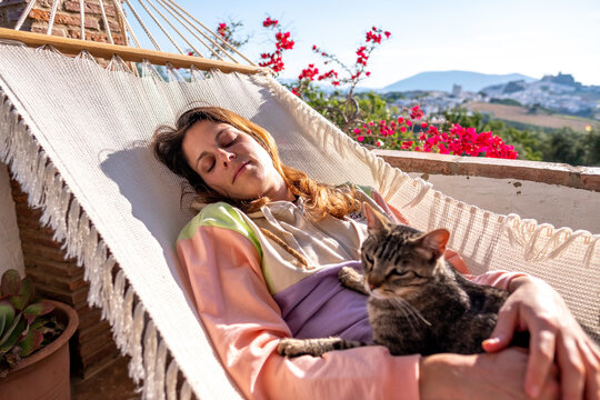 Young woman in hammock with her cat