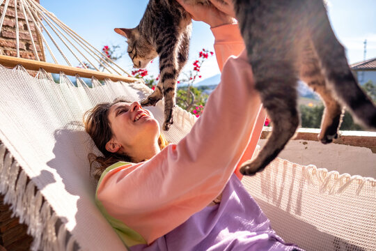 Young woman in hammock with her cat